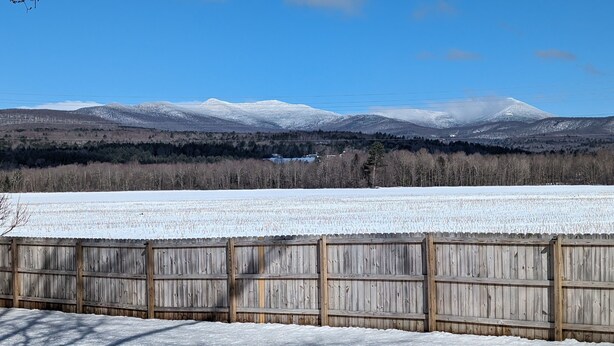 A snowy landscape with a wooden fence in the foreground and a mountain range in the background. - Stowe Retreat Mountain Views & Fenced Backyard by RedAwning (Stowe)