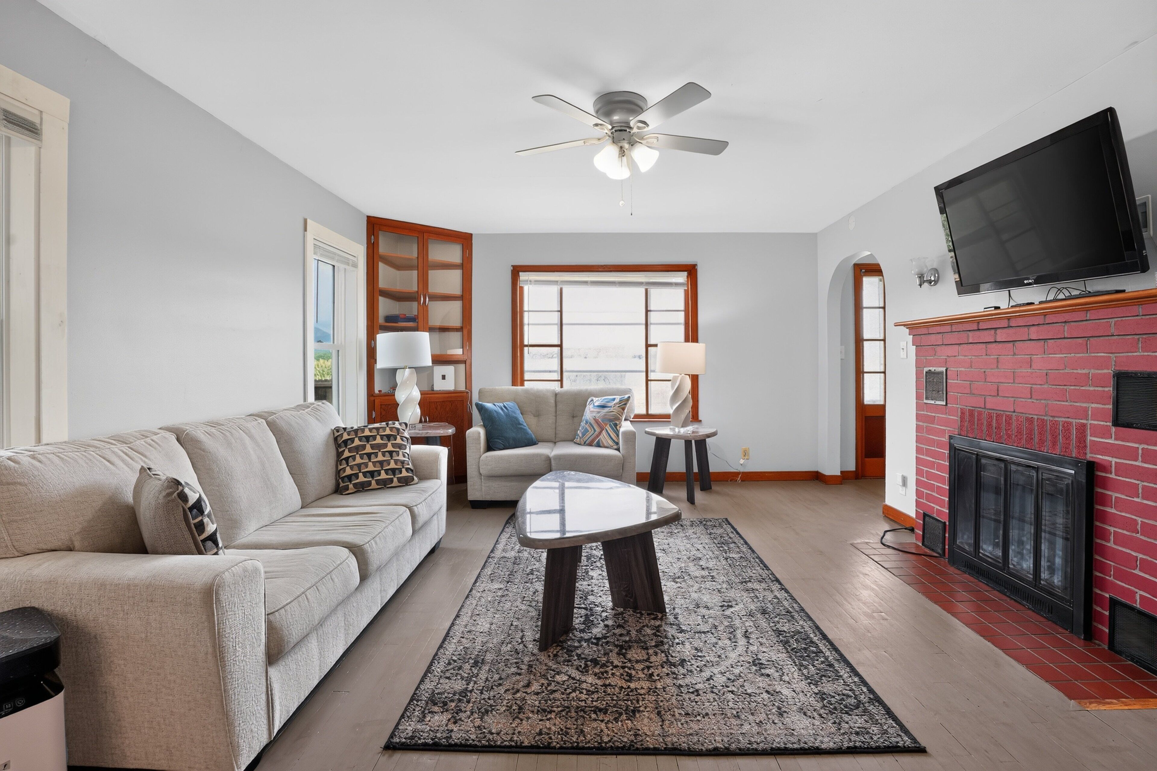 A living room with a sofa, coffee table, and fireplace.