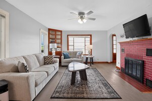 Una sala de estar con sofá, mesa de centro y chimenea.
