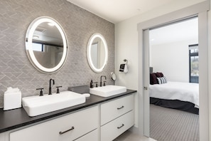 A modern bathroom with two sinks, a mirror, and a towel dispenser. - Timber Fox 1208 3 Bedroom Apts by RedAwning (Winter Park)