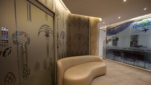 Un intérieur moderne avec un espace salon aux lignes courbes, des motifs décoratifs sur les murs et un panneau « Coltours » bien visible.