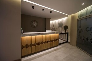 Welcome to our reception area, featuring a central desk with a stylish design and a wall-mounted clock.
