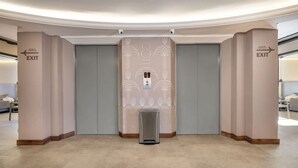 A modern elevator with a decorative wall panel and an exit sign. - Modern Loft in city downtown near Metro station (Medellín)
