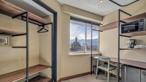 A compact kitchen with a view of a cityscape, a hanging coat rack, and a small dining area. - Modern Loft in city downtown near Metro station (Medellín)