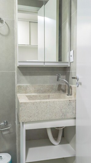 A bathroom with a granite countertop sink, a mirror, and a towel rack. - Flat Zero7 Villa del Porto com piscina  (Ipojuca)