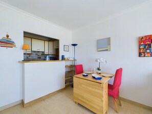 A compact kitchen with a dining area, a small table, and chairs.