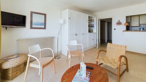 Ein Wohnzimmer mit Fernseher, gerahmtem Bild und Bücherregal.