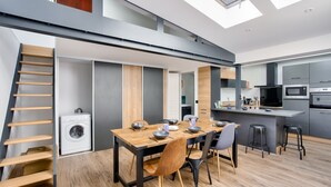 Una cocina moderna con microondas integrado, horno y una isla grande con taburetes de bar.