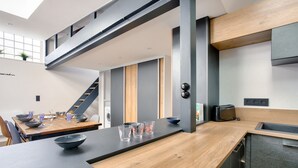 Una cocina moderna con encimera de madera, lavavajillas integrado y tostadora.