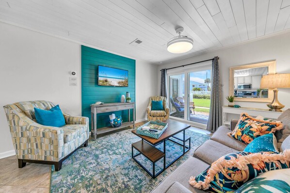 A living room with a teal accent wall, a fireplace, a sofa, and a coffee table.