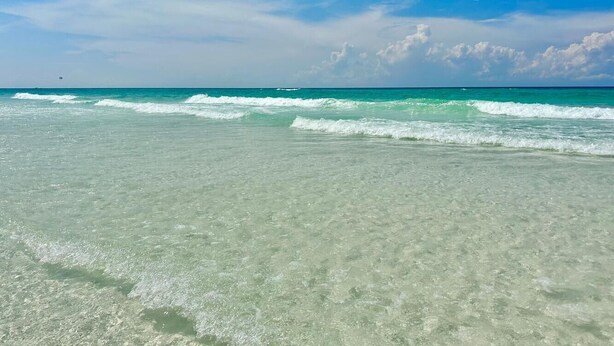 A beach with clear turquoise water and a clear sky. - 🏖️Tradewinds 21 - Coastal Charm | Easy Beach Access | Steps to Pool🏖️ (Miramar Beach)