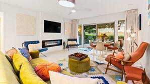 Ein modernes Wohnzimmer mit einer Couch, einem Sessel und einem Kamin.