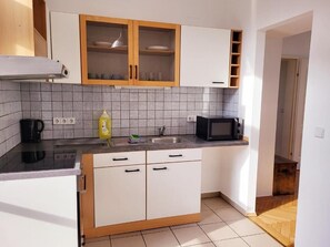 Apartamento, sacada | Cozinha privada | Geladeira, micro-ondas, fogão, cooktop