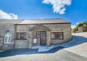 Traditional stone building with a central entrance and symmetrical facade.