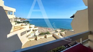 Un balcon avec vue sur une plage et la mer.