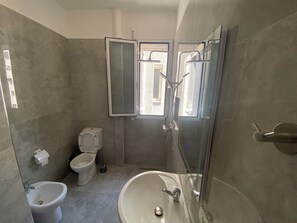 Een douche, een haardroger, een bidet, handdoeken