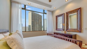 Une chambre d’hôtel avec un grand lit, une commode et une fenêtre donnant sur la ville.