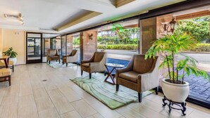 Un hall d’entrée avec des fauteuils en cuir, une table basse et une plante en pot.
