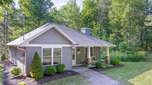A single-story house with a porch, surrounded by a well-maintained lawn and trees. - Blue Bear Cottage: Serene Fish Creek Escape (Fish Creek)