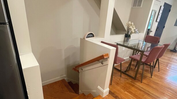 A modern kitchen with a wooden staircase leading to a dining area. - Chic 5-bedroom/ 2 B apartment in Washington with AC, WiFi (Washington)