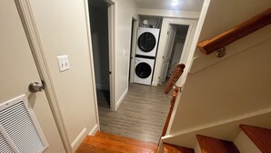 A hallway leading to a laundry room with a washing machine and dryer. - Chic 5-bedroom/ 2 B apartment in Washington with AC, WiFi (Washington)