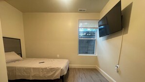 A bedroom with a bed, a window, and a TV mounted on the wall. - Chic 5-bedroom/ 2 B apartment in Washington with AC, WiFi (Washington)