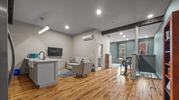 A spacious living area with a kitchen, a sofa, and a dining table. - Modern Studio - Main St Penn Yan (Penn Yan)