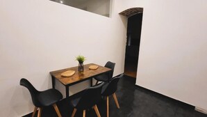 Un comedor con una mesa, sillas y una planta pequeña.