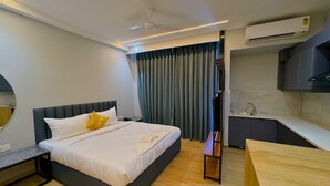 A modern hotel room with a bed, bedside table, and a small wooden table. - Lime Tree Hotel Sector 51 Gurgaon (Gurugram)