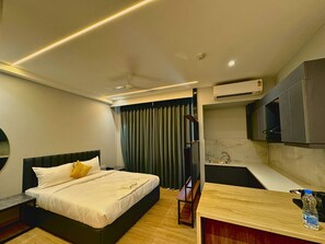 Ein modernes Hotelzimmer mit einem Bett, einem kleinen Schreibtisch, einem Spiegel und einem Fenster mit Vorhängen.