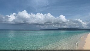 Ein Strand mit klarem türkisblauem Wasser und sandigem Ufer.