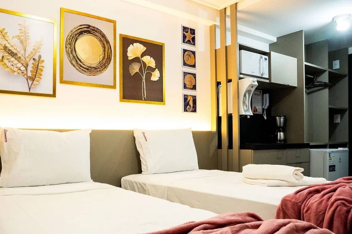 A hotel room with two beds, a coffee machine, and a microwave.