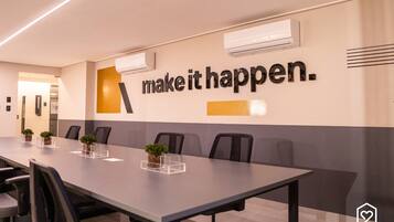 A conference room with a long table, chairs, and a motivational quote on the wall.