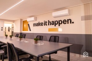 A conference room with a long table, chairs, and a motivational quote on the wall. - Move Tambaú (João Pessoa)