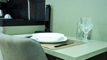 A table with a plate, a knife, a glass, and a bottle.