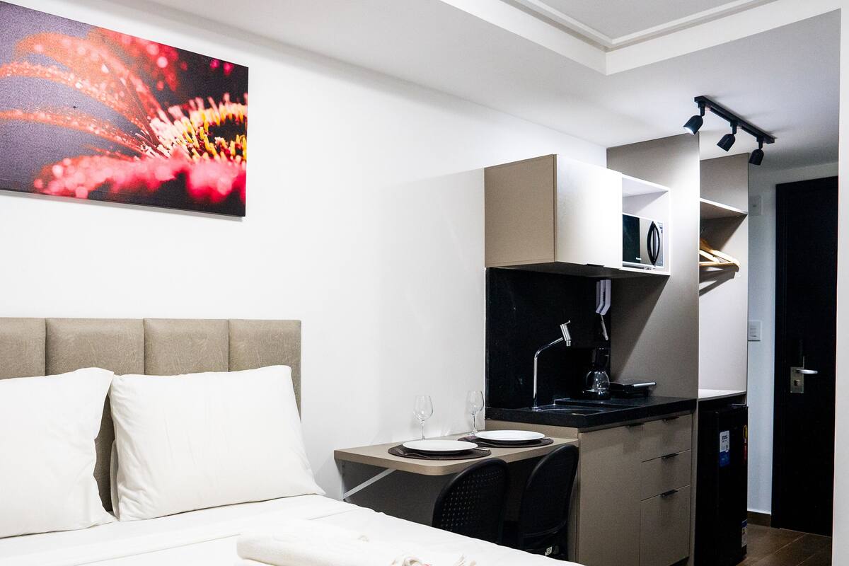 Ein Hotelzimmer mit einem Bett, einem Schreibtisch und einer Küchenzeile.