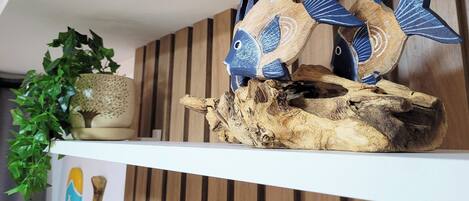 A shelf with decorative fish figures and a plant.