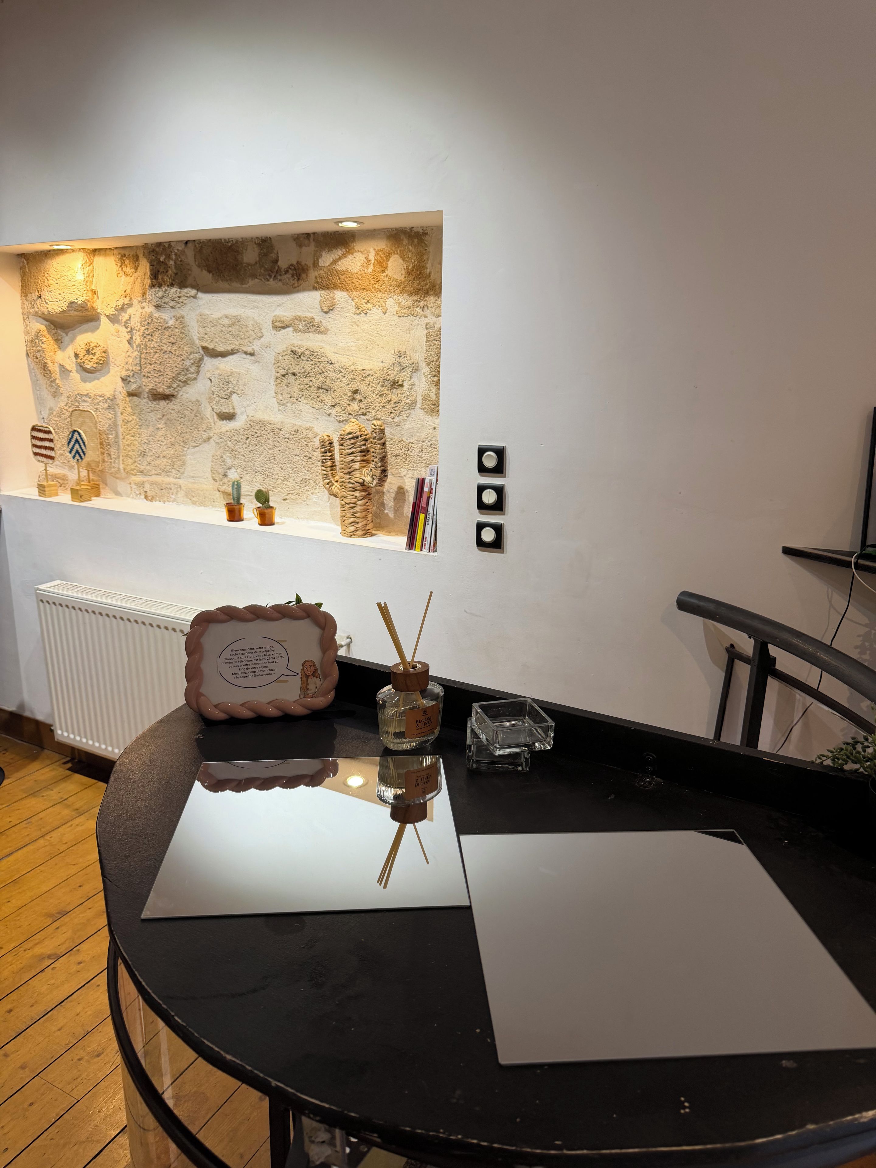 A room with a stone wall, a black table, and a white radiator.