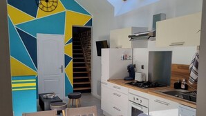 Uma cozinha moderna com área de refeições, claraboias e design geométrico na parede.