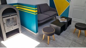 Uma sala de estar moderna com um sofá, uma mesinha redonda, uma mesa de centro e uma lareira.