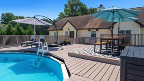 A backyard with a swimming pool, deck chairs, umbrellas, and a wooden deck. - An Oasis Awaits You with Vineyard Views (McDonough)