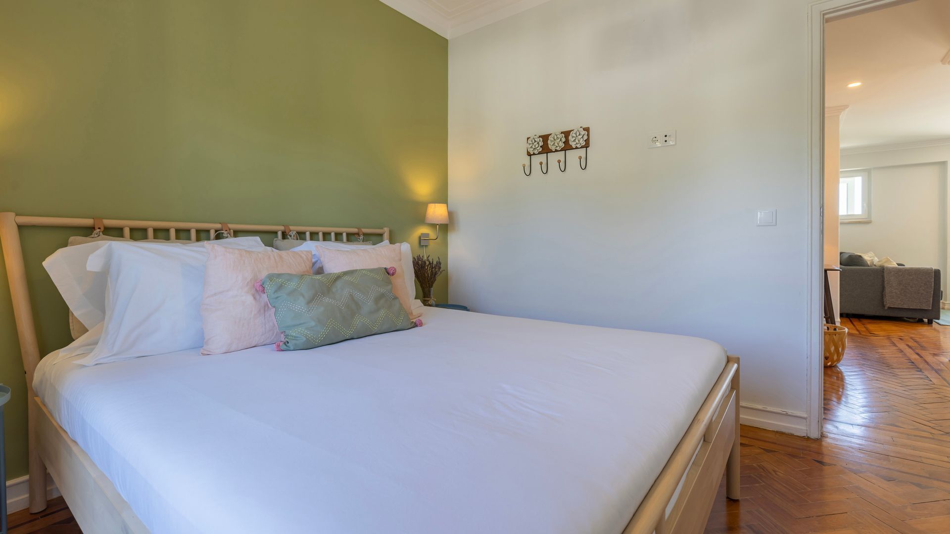 Un dormitorio con cama, mesita de noche, lámpara y un adorno en la pared.