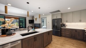 Una cocina moderna con una isla grande, electrodomésticos de acero inoxidable y una chimenea.