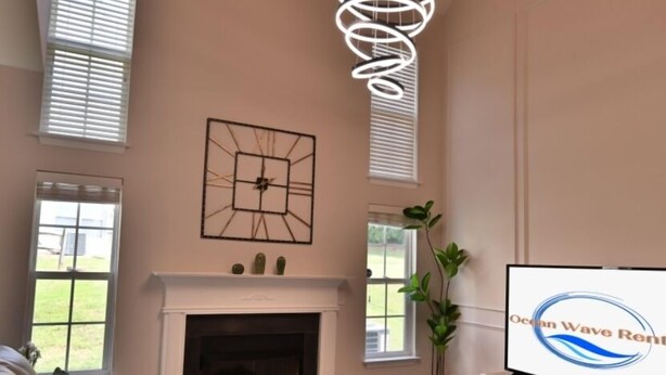 Amplia sala de estar con chimenea, un sofá, una mesa de centro y un televisor.