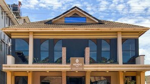 A two-story building with a sign reading "HENDO LOUNGE RESTAURANT CONFERENCE SUITES". - Hendo Hotel (Entebbe)