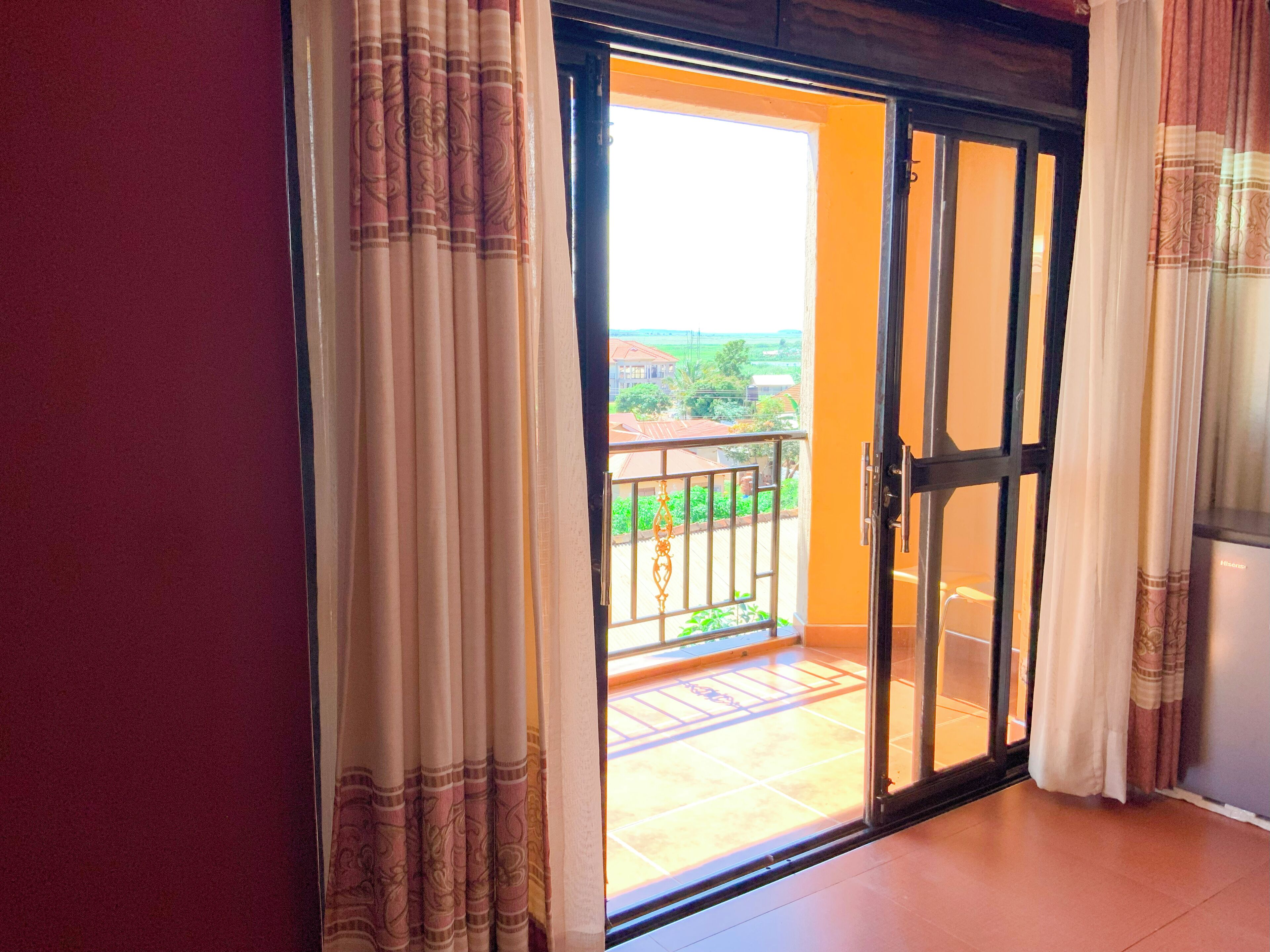 Quarto com porta de correr de vidro que dá para uma varanda com guarda-corrimão de metal.