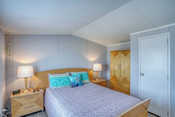 Una camera da letto con un letto, due comodini con lampade, un armadio e una sveglia.