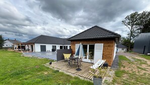 A residential property with a patio area, a covered outdoor seating area, and a small garden. - Gîte Du Vieux Chêne (Plaine)