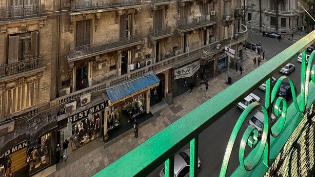 Un edificio de varios pisos con detalles arquitectónicos ornamentales, incluyendo balcones y elementos decorativos.