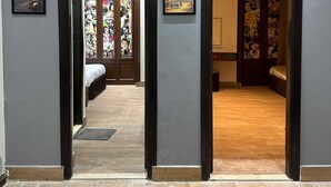 Un pasillo con dos puertas que dan a dormitorios, cada uno con cama y mesita de noche.
